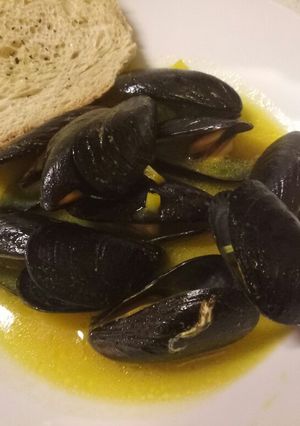 A picture of Mussels in a white wine & saffron sauce with oregano bruschette.