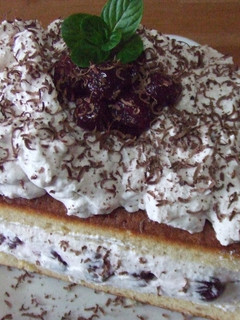 Una foto de Bizcocho con cerezas, chantilly y chocolate