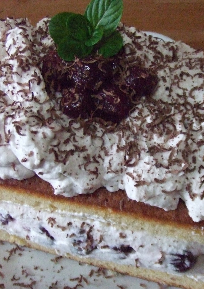 Una foto de Bizcocho con cerezas, chantilly y chocolate