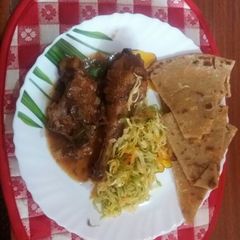 A picture of Wet fried chicken served with cabbage and chapati.