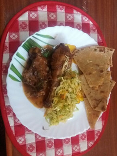 A picture of Wet fried chicken served with cabbage and chapati.