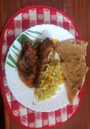 A picture of Wet fried chicken served with cabbage and chapati.