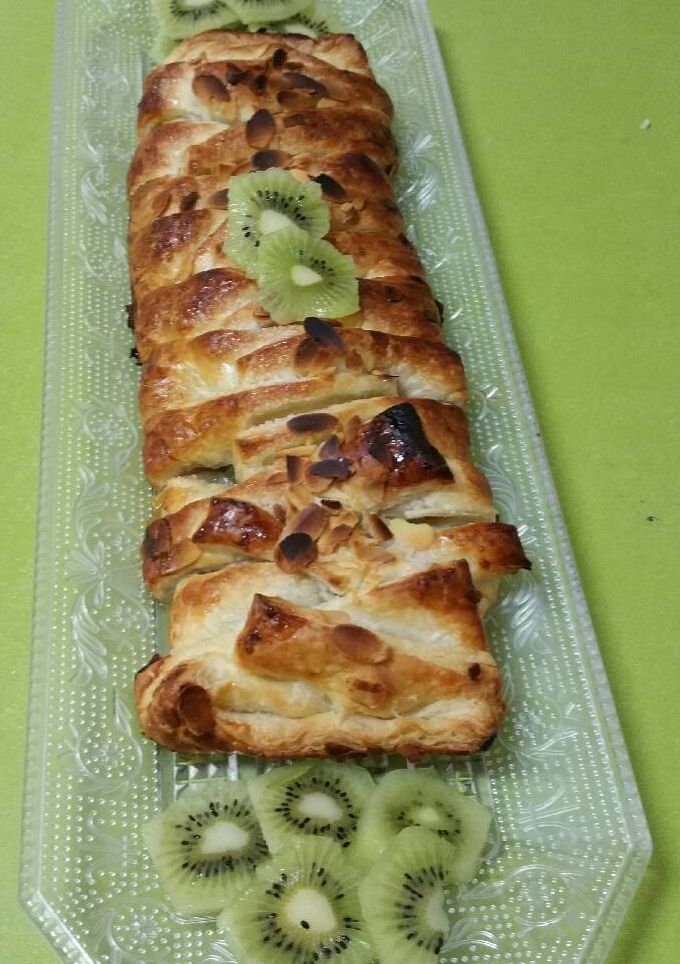 Una foto de Una trenza de hojaldre rellena de kiwi, nueces y pasas