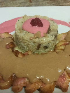 Una foto de Magret de pato con salsa de chocolate y guarnicion de arroz y setas con salsa de frambuesa