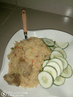 A picture of Jollof rice and cucumber.