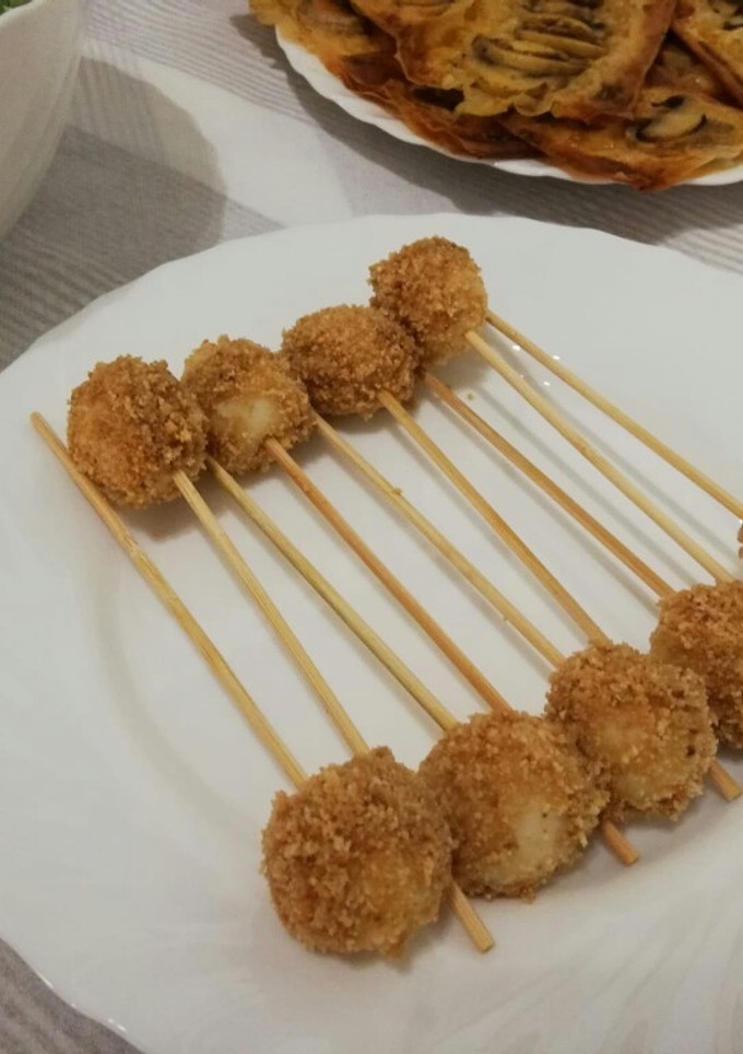 Una foto de Pinchos de huevos de codorniz empanados en piñones