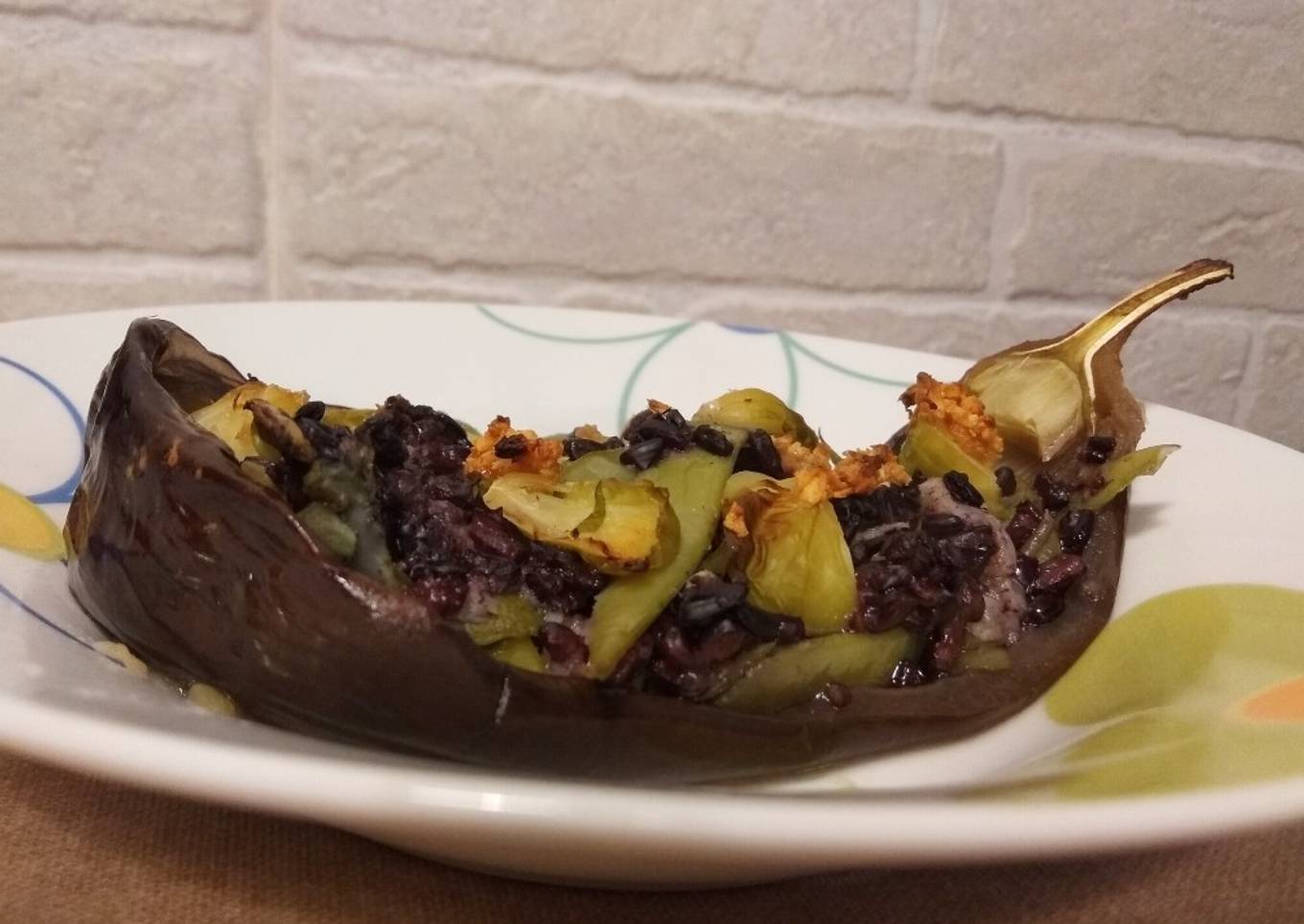 Berenjena asada rellena de arroz negro y verduras