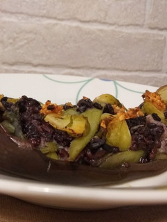 Una foto de Berenjena asada rellena de arroz negro y verduras