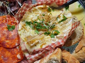 Une photo de Camembert rôti et charcuterie