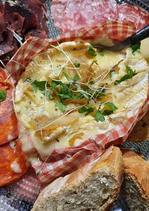 Une photo de Camembert rôti et charcuterie