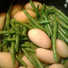 A picture of Green beans and new potatoes, aka dinosaur eggs in a nest.
