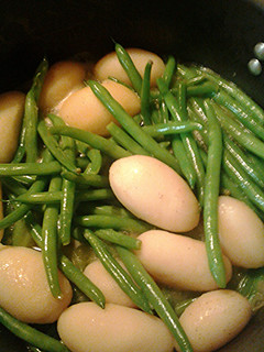 A picture of Green beans and new potatoes, aka dinosaur eggs in a nest.