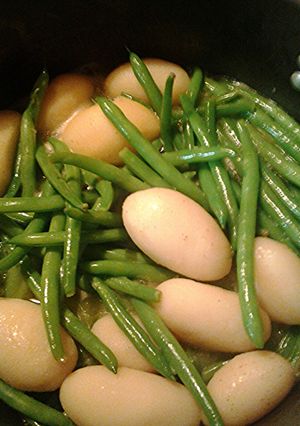 A picture of Green beans and new potatoes, aka dinosaur eggs in a nest.