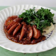 A picture of Spotted Trotter Chicken Currywurst Stewed in a Madras Curry Sauce with Russet Potatoes and Kale.