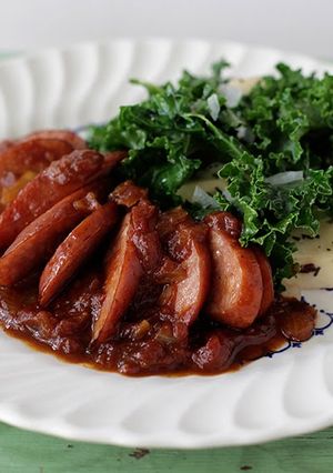 A picture of Spotted Trotter Chicken Currywurst Stewed in a Madras Curry Sauce with Russet Potatoes and Kale.