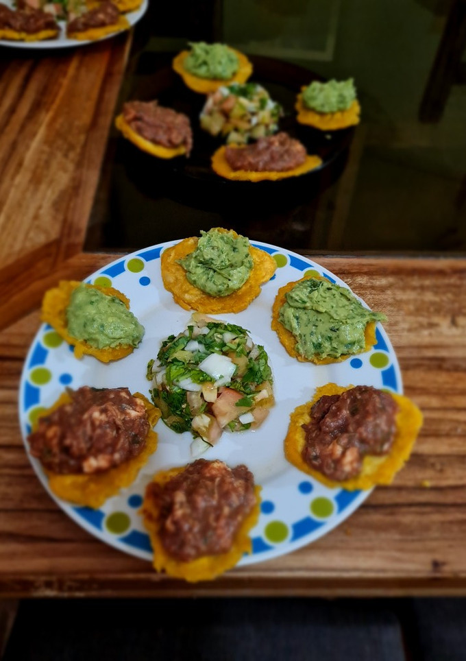 Una foto de Patacones, con frijoles con queso y con guacamole