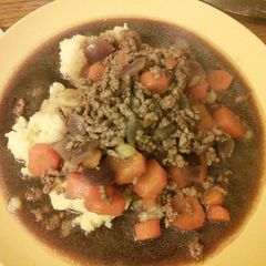 A picture of Minced beef & onion with mash & gravy.