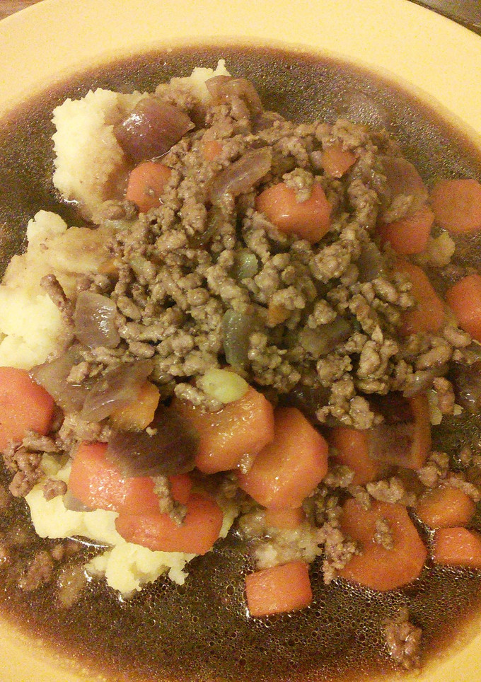 A picture of Minced beef & onion with mash & gravy.