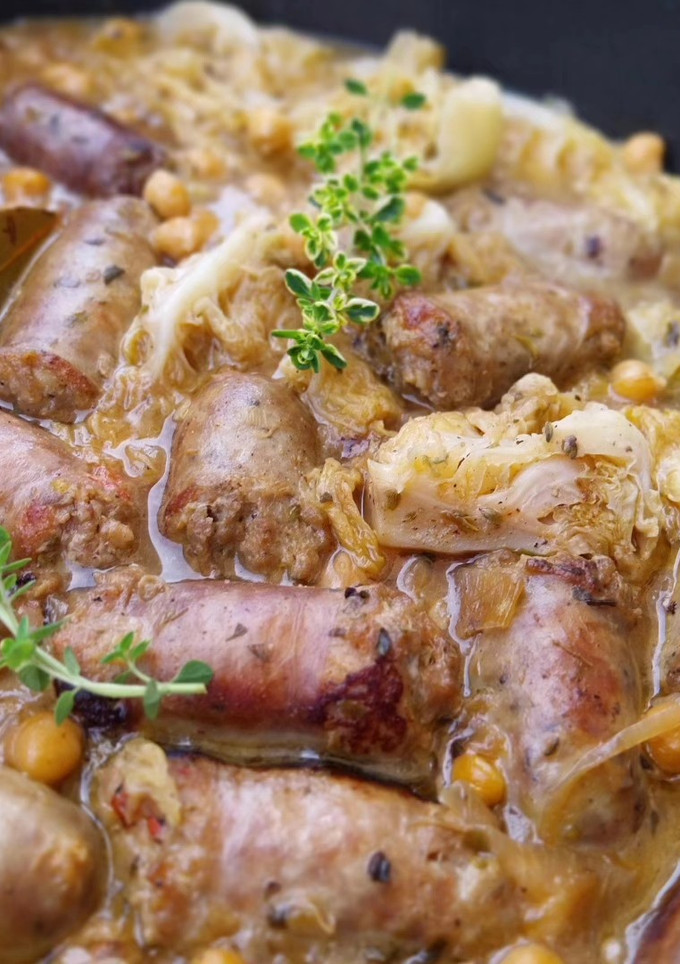 Una foto de Cazuela de butifarras salteadas con col y garbanzos