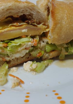 Una foto de Bocata tortilla jamón York, queso con pan chapata y ensalada con soja