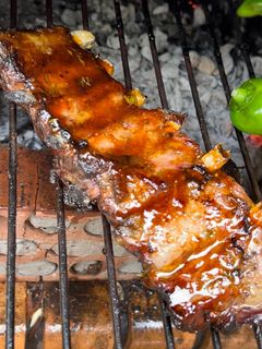 Una foto de Costillar de ibérico a la brasa con barbacoa de naranja, tomillo y miel