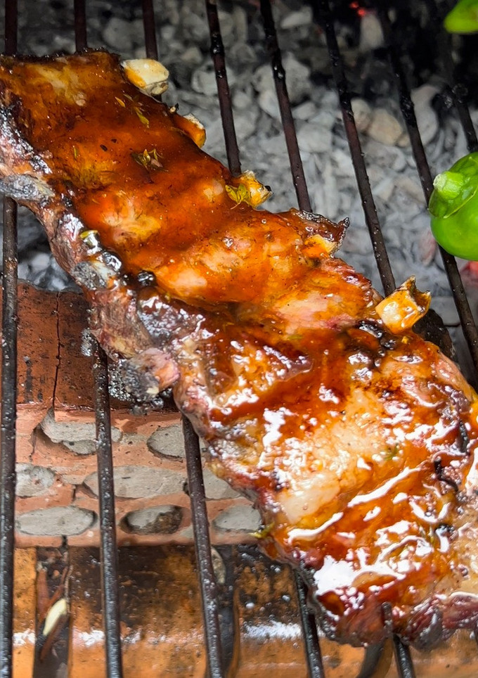 Una foto de Costillar de ibérico a la brasa con barbacoa de naranja, tomillo y miel