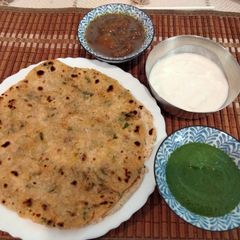 A picture of Akki roti with green chutney,curd and mango launji.