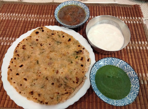 A picture of Akki roti with green chutney,curd and mango launji.