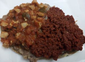 Una foto de Carne de puerco a la mexicana tipo ranchero con frijoles rojos en huarache