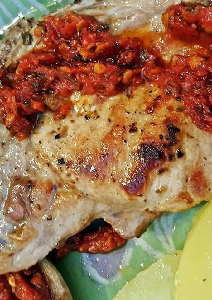 Una foto de Chuleta de cerdo con salsa de tomate aromatizada al ajo
