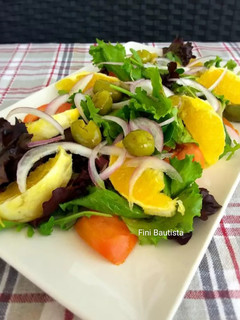 Una foto de Ensalada con naranja aceitunas partidas y brotes tiernos