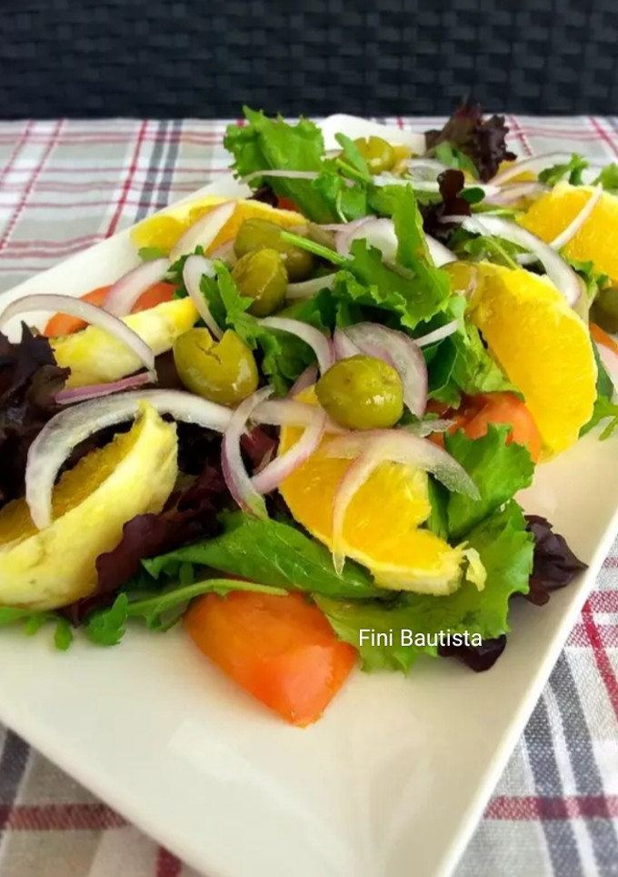 Una foto de Ensalada con naranja aceitunas partidas y brotes tiernos