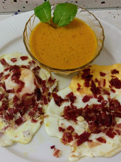 Una foto de Huevos fritos con jamón ibérico y crema de calabaza