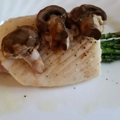 A picture of Baked Halibut with asparagus and mushrooms.