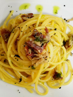 Una foto de Espaguetis carbonara ibérica con trufa y aceite de cebollino