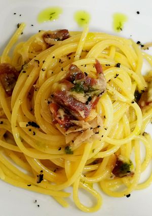 Una foto de Espaguetis carbonara ibérica con trufa y aceite de cebollino
