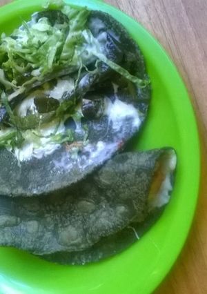 Una foto de Quesadillas Mexicanas  de tortilla azul con rajas, lechuga y salsa verde pobre ranchera