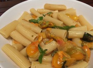 Una foto de Rigatoni amarillos (tomatitos y flores de zucchini)
