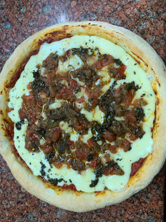 Una foto de Pizza de leudado en heladera con mozzarella, tomate y berenjena