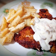 A picture of chicken breast with cheesy mushroom sauce.