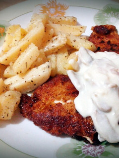 A picture of chicken breast with cheesy mushroom sauce.