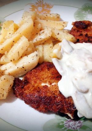 A picture of chicken breast with cheesy mushroom sauce.