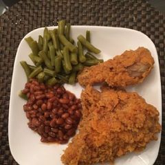 A picture of Chicken with green peas and baked beans.