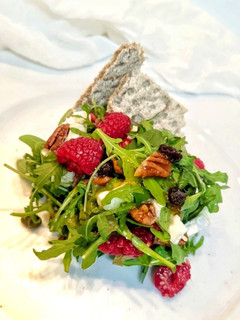 Una foto de Ensalada fresca de rúcula, queso de cabra y frambuesas