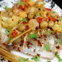 A picture of Steamed pomfret with sautéed vegetables.