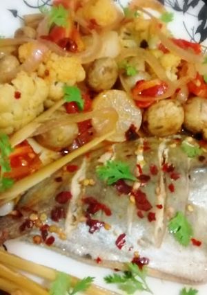 A picture of Steamed pomfret with sautéed vegetables.