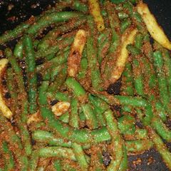 A picture of String beans with bread crumbs.