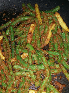 A picture of String beans with bread crumbs.