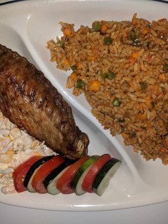 A picture of Jollof rice,fried turkey and coleslaw.