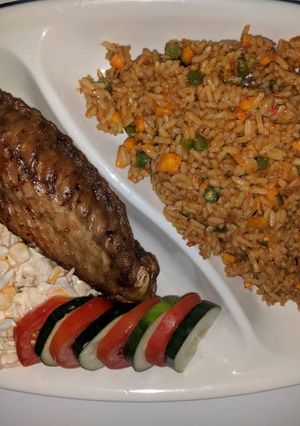 A picture of Jollof rice,fried turkey and coleslaw.